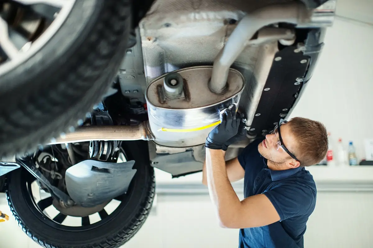 mechanik oglądający podwozie samochodu